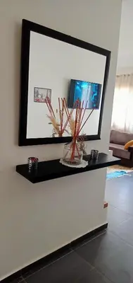 a mirror on a wall in a living room at Appartement Familial avec Jardin, Résidence avec Piscine Dar El Bahr in Sidi Rahal