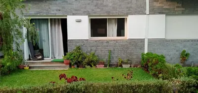 a cat sitting in the window of a house at Appartement Familial avec Jardin, Résidence avec Piscine Dar El Bahr in Sidi Rahal