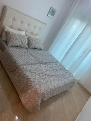 a bedroom with a bed with a white headboard at A 5 minutes à pied de la plage un bel appartement à saisir in Sidi Rahal