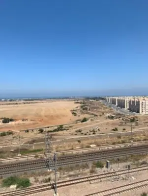 a view of a city with train tracks and buildings at Appart. Luxueux avec piscine, cosy, bien situé in Bouznika