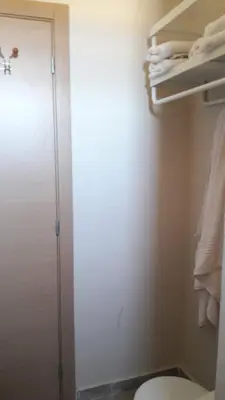 a bathroom with a toilet and a closet with towels at Appart. Luxueux avec piscine, cosy, bien situé in Bouznika