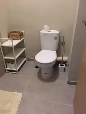 a bathroom with a white toilet in a room at Appart. Luxueux avec piscine, cosy, bien situé in Bouznika