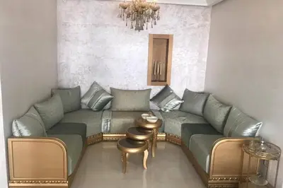 a living room with a couch and a table at Très bel appartement neuf à Mansbay Manssouria in Mohammedia