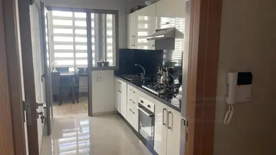 a kitchen with a sink and a stove top oven at Très bel appartement neuf à Mansbay Manssouria in Mohammedia