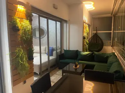 a living room with a green couch and a table at Très bel appartement neuf à Mansbay Manssouria in Mohammedia