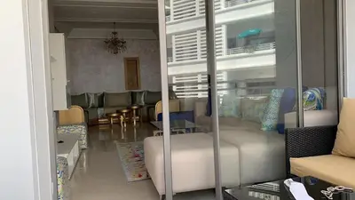 a living room with a couch and a table and chairs at Très bel appartement neuf à Mansbay Manssouria in Mohammedia