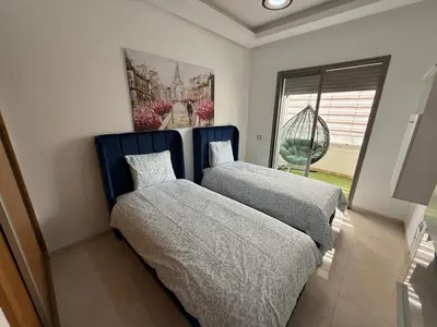 a bedroom with two beds and a window at Très bel appartement neuf à Mansbay Manssouria in Mohammedia