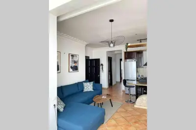 a living room with a blue couch and a table at Appartement vue mer panoramique in Tamaris