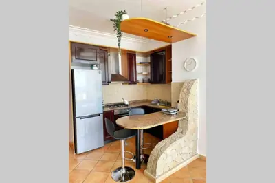 a small kitchen with a table and a refrigerator at Appartement vue mer panoramique in Tamaris