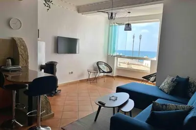 a living room with a blue couch and a table at Appartement vue mer panoramique in Tamaris