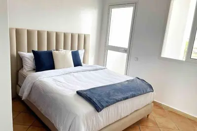 a bedroom with a large bed with blue pillows at Appartement vue mer panoramique in Tamaris