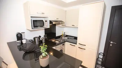 a kitchen with a black counter top and a microwave at Appartement chic en plein Gauthier in Casablanca