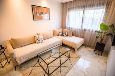 a living room with a couch and a glass table at Appartement chic en plein Gauthier in Casablanca