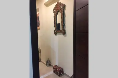 a mirror hanging on a wall in a room at Beautiful apart Agdal in Rabat