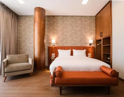 a bedroom with a bed and a chair at BH Appart Hotel in Casablanca