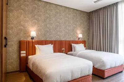 two beds in a hotel room with white sheets at BH Appart Hotel in Casablanca
