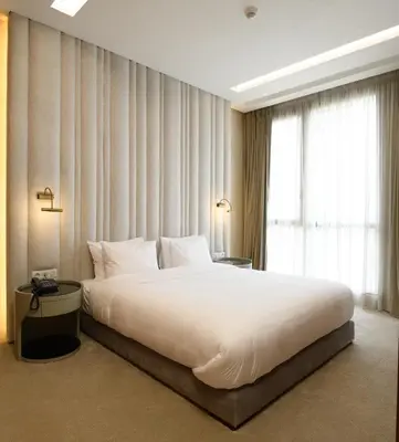 a bedroom with a large white bed and a window at BH Appart Hotel in Casablanca