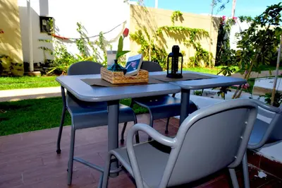 a blue table with chairs and a bottle of wine at CASABAY Sidi Rahal, appartement avec accés direct à la plage et piscine in Sidi Rahal