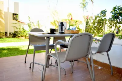 a table and chairs sitting on a patio at CASABAY Sidi Rahal, appartement avec accés direct à la plage et piscine in Sidi Rahal