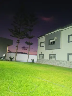 a white house with two trees in a yard at Villa Safaa Dar Bouazza in Dar Mouddene