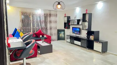 a living room with a red couch and a tv at Studio de luxe in Casablanca