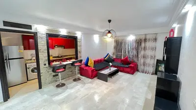 a living room with a red couch and a kitchen at Studio de luxe in Casablanca