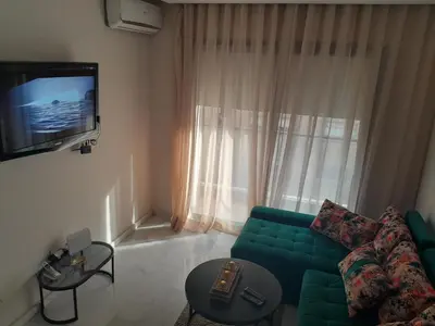 a living room with a green couch and a television at Derb Omar,Tram (L1,L2,L3),Parking and wifi gratuit in Casablanca