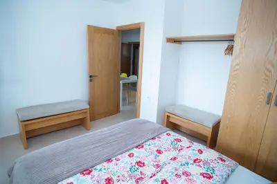 a bedroom with a bed and two benches in it at My Cosy Place Rabat - Appartements à 50m de la gare Agdal TGV in Rabat