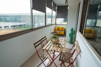 two chairs and a table in a room with windows at My Cosy Place Rabat - Appartements à 50m de la gare Agdal TGV in Rabat