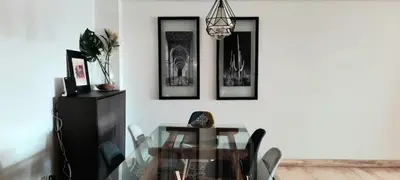 a dining room with a glass table and pictures on the wall at Grand appartement de luxe vue mer in Casablanca