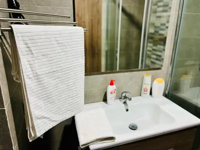 a bathroom sink with a towel and a mirror at OceanParc - Vue sur Mer et Parc 24H Sécurité in Mohammedia