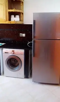 a kitchen with a refrigerator and a washing machine at Housse coral famille in Casablanca