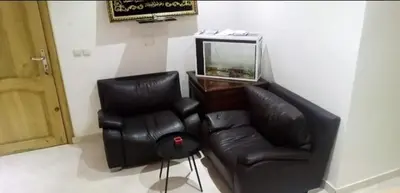 a living room with a leather couch and a chair at Housse coral famille in Casablanca