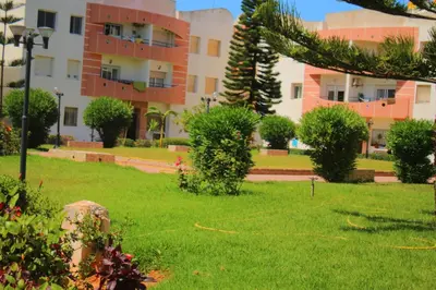 a green yard with a building in the background at Mohammedia vive les vacances in Mohammedia