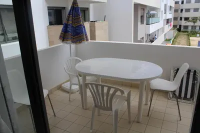a table and chairs in a room with a window at Fermer Appartement dans résidence Paradis Beach in Mohammedia