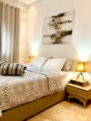 a bedroom with a bed and a painting on the wall at Apparemment de luxe vue piscine in Bouznika