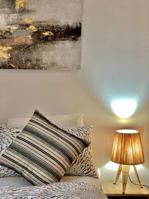 a bed with a striped pillow next to a lamp at Apparemment de luxe vue piscine in Bouznika