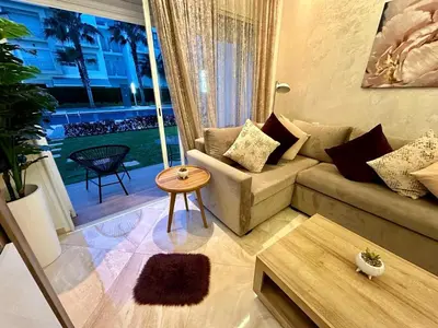 a living room with a couch and a table at Apparemment de luxe vue piscine in Bouznika