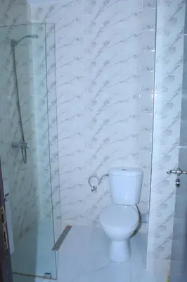 a bathroom with a toilet and a glass shower at BOUZNIKA Appartement 4 in Bouznika