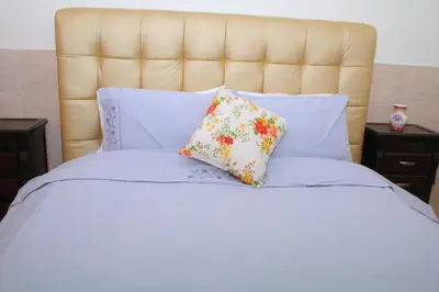 a white bed with two pillows on it at Appartement au centre ville in Bouznika