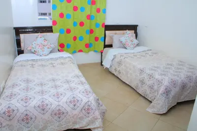a bedroom with two beds and a colorful wall at Appartement au centre ville in Bouznika