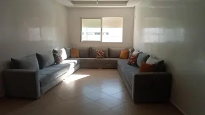 a living room with two couches and a window at Appartement au centre ville in Bouznika