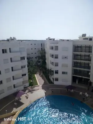 a large swimming pool in front of some buildings at Appartement - Bouznika Centre in Bouznika
