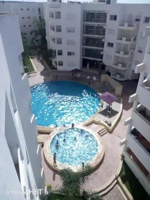 a large swimming pool in the middle of a building at Elegant Appartement in Bouznika in Bouznika