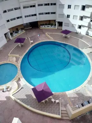 an overhead view of a large swimming pool with umbrellas at Elegant Appartement in Bouznika in Bouznika