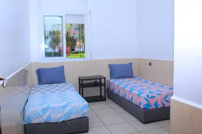 a bedroom with two beds and a window at MOHAMMEDIA Plage à 300m et piscine sur place in Mohammedia