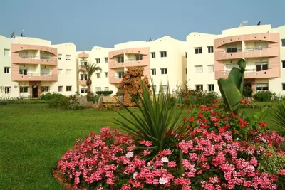 a view of a building with flowers in a yard at MOHAMMEDIA Plage à 300m et piscine sur place in Mohammedia