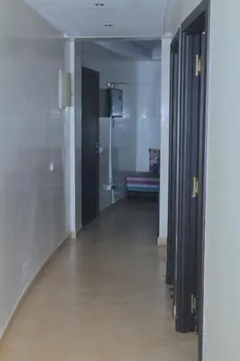 a hallway with two doors and a couch in a room at BOUZNIKA Appartement avec piscine in Bouznika