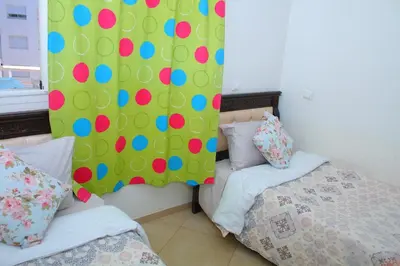a bedroom with two beds and a wall with polka dots at BOUZNIKA Appartement avec piscine in Bouznika