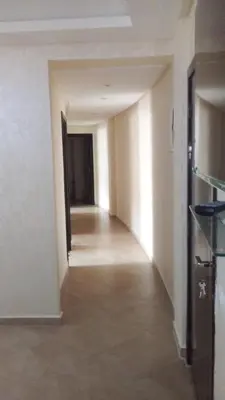 an empty hallway in a building with white walls at BOUZNIKA Appartement in Bouznika